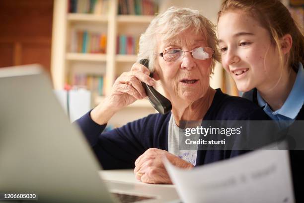 grandmother paying by telephone - grandma invoice stock pictures, royalty-free photos & images