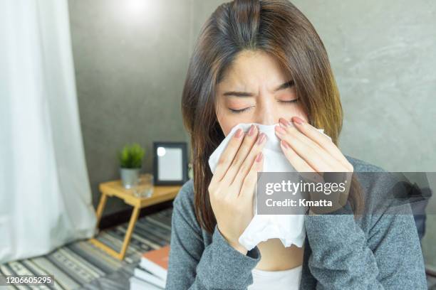 woman with allergy symptom blowing nose. - sinus stock pictures, royalty-free photos & images