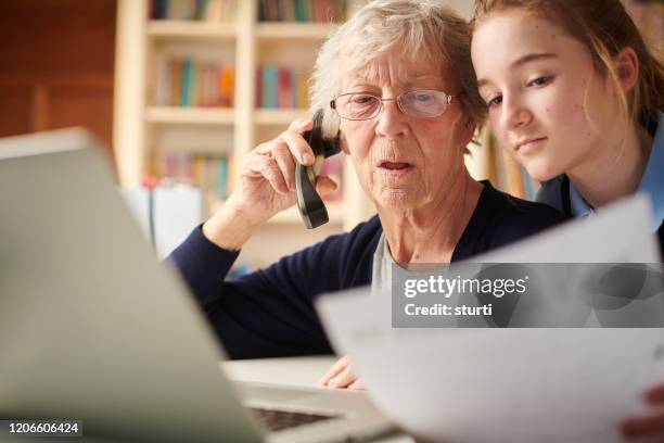mormor betalar per telefon - grandma invoice bildbanksfoton och bilder