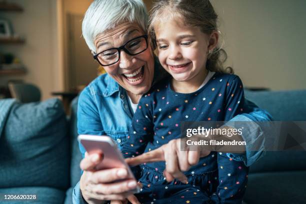 portrait of grandmother and granddaughter - smartphone video stock pictures, royalty-free photos & images