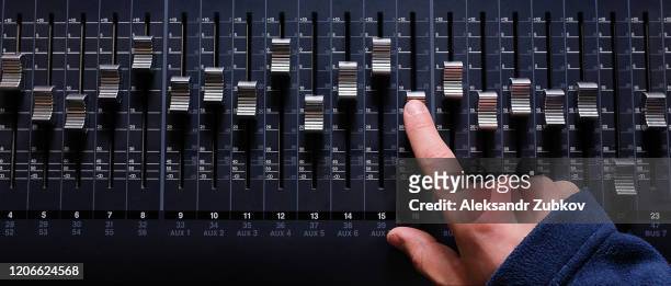 amplifying equipment that adjusts studio audio mixer knobs and faders. workplace and equipment of the sound engineer. acoustic mixing of music, selective focus. banner. - adjusting stockfoto's en -beelden