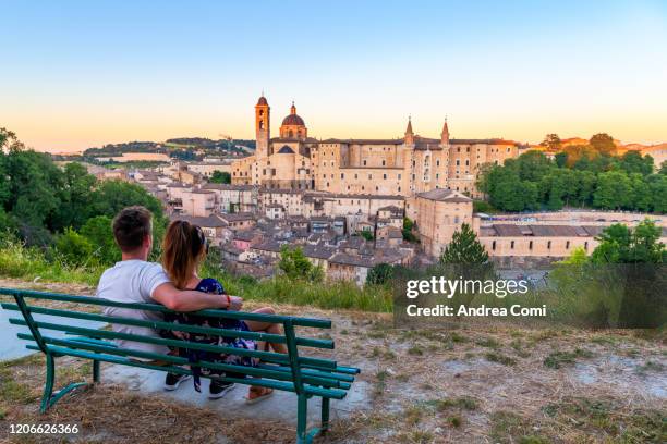 couple of young tourists admiring the view over the historic center of urbino. italy - marche italia - fotografias e filmes do acervo