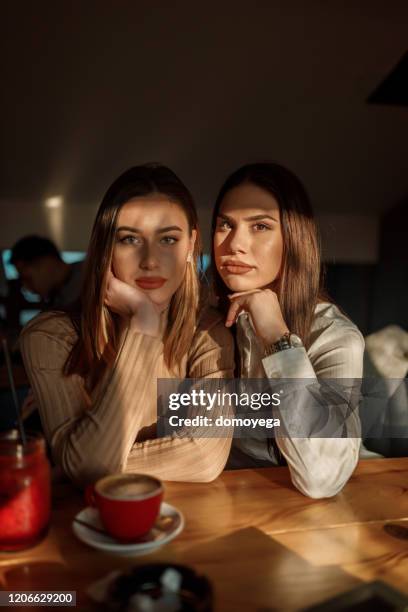 twee tienermeisjes die in koffiestaaf zitten - bar girl stockfoto's en -beelden