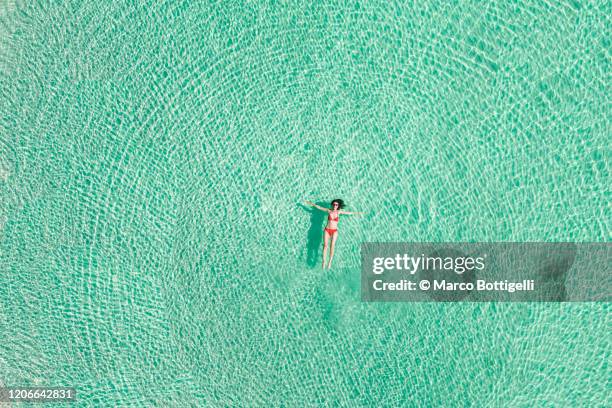 aerial overhead view of woman relaxing on caribbean sea, mexico - playa del carmen photos et images de collection