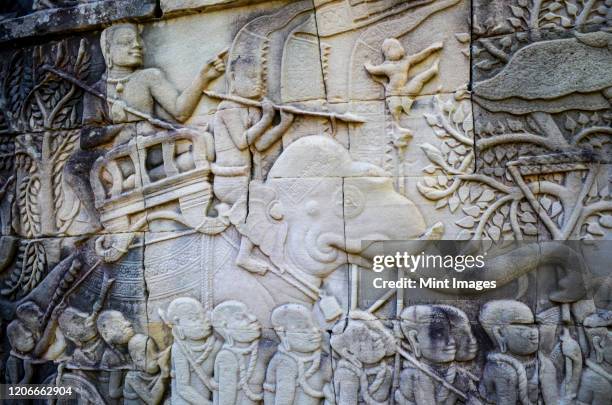 angkor wat, a 12th century historic khmer temple and unesco world heritage site. arches and carved stone bas relief panels with scenes from khmer cultural history. - bas reliëf stockfoto's en -beelden
