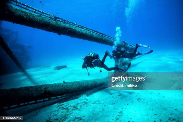 scuba divers at wreck diving - shipwreck underwater stock pictures, royalty-free photos & images