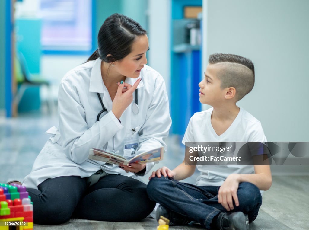 Terapeuta del habla sentado con un niño foto de archivo