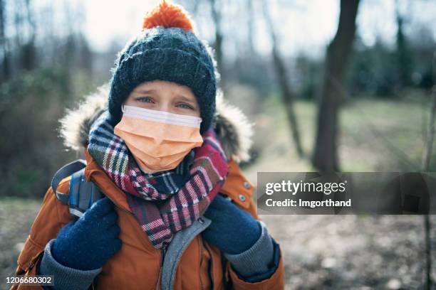 porträt eines kleinen jungen mit antiviren-maske - coronavirus winter stock-fotos und bilder