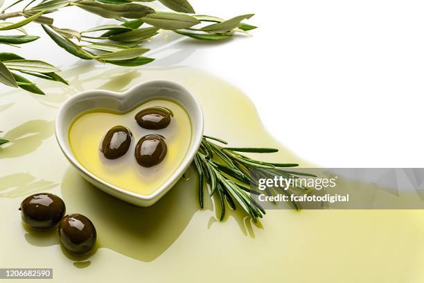 heart shaped bowl filled with olive oil on white background. copy space. - extra virgin olive oil stock pictures, royalty-free photos & images