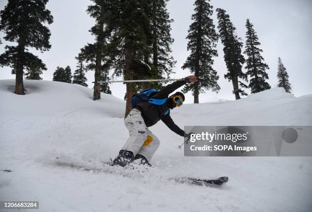 Skier in action at the famous ski resort during a sunny day in Gulmarg. Gulmarg Resort is a big ski hill serviced by a gondola. The ski season starts...