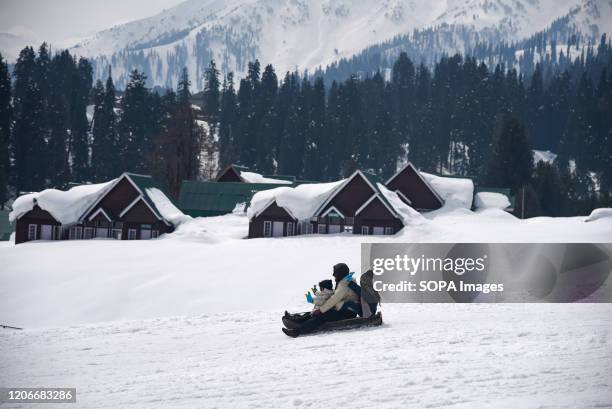 Tourists enjoying a ride on a snow sledge at famous ski resort in Gulmarg. Gulmarg Resort is a big ski hill serviced by a gondola. The ski season...