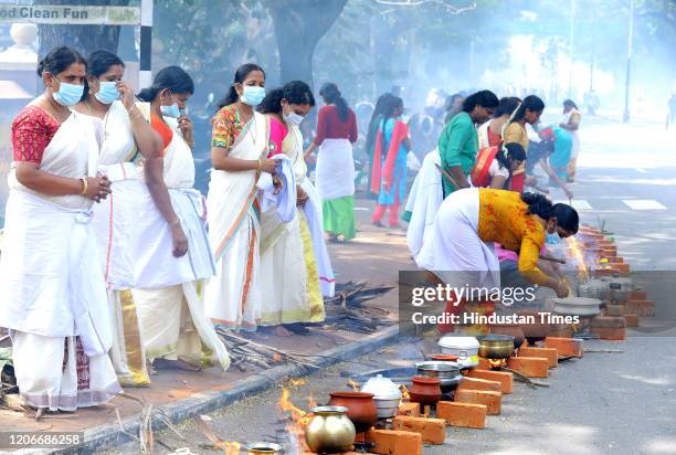 Women seen wearing facemasks amid rising Coronavirus scare, as they offer Pongala -- a gruel made of rice, jaggery, ghee and coconut during Attukal...