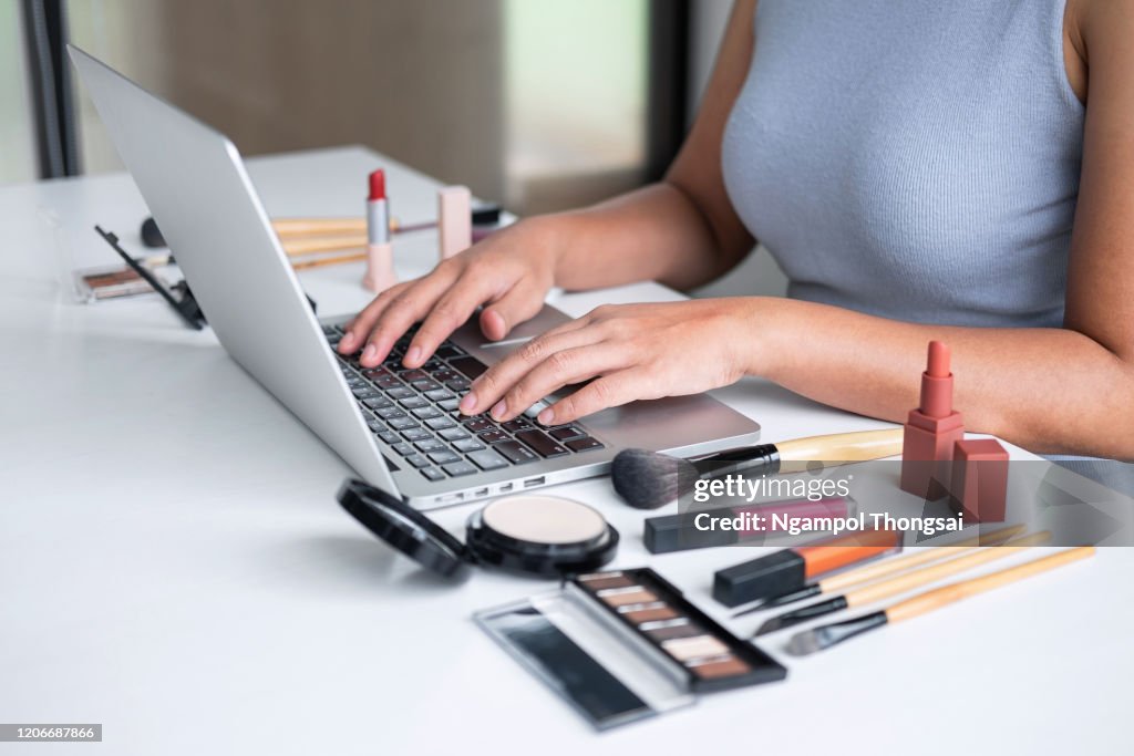 Business online on social media, Beautiful woman is watching online blogger tutorial on laptop, showing present tutorial beauty cosmetic using product makeup