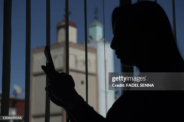 Loubna, a 27-year-old Moroccan victim of cyberbullying, uses her phone in the coastal city of Casablanca on March 9, 2020. - In Morocco, more than...