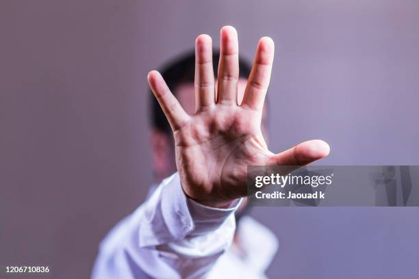 view of a man showing his hand hiding his face - stop gesture - hand stop stock-fotos und bilder