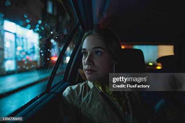 kvinna njuter av en taxiresa under natten - taxi worried bildbanksfoton och bilder