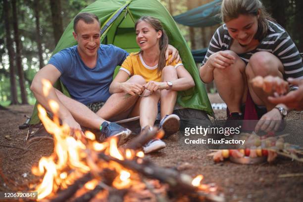 couple bonding near a camp fire - campfire storytelling stock pictures, royalty-free photos & images