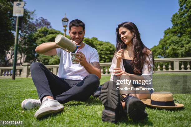 mann gießt yerba mate für seine latino freundin - yerba mate stock-fotos und bilder