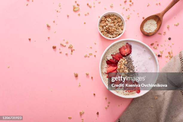 a bowl of healthy and delicious strawberry smoothie with grains and fresh fruit. - smoothie bowl fotografías e imágenes de stock