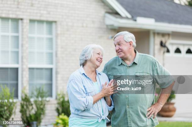 coppia senior in piedi davanti a casa - large garden foto e immagini stock