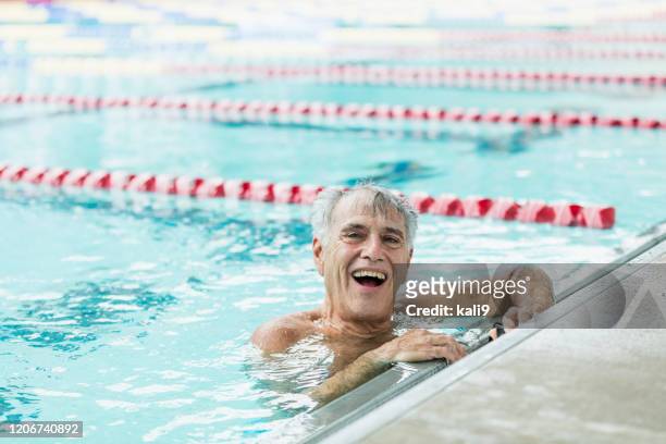 senior-mann im pool macht pause von schwimmrunden - sport bahnrunde stock-fotos und bilder