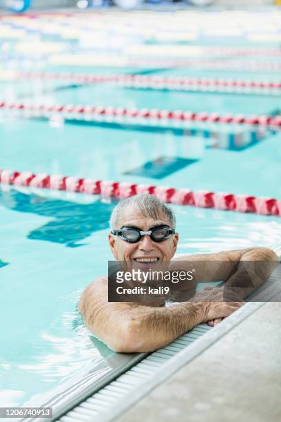 senior-mann im pool macht pause von schwimmrunden - sport bahnrunde stock-fotos und bilder