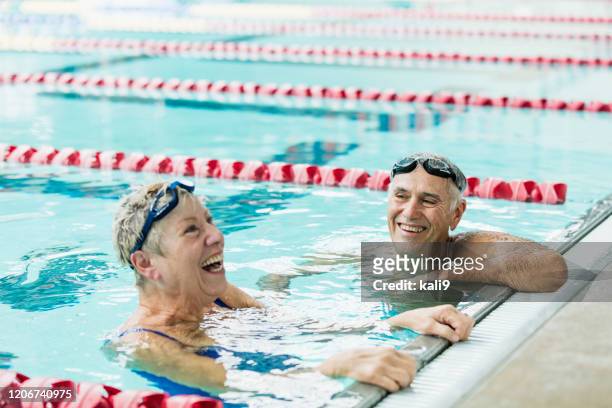 seniorenpaar trainiert zusammen, schwimmrunden - sport bahnrunde stock-fotos und bilder