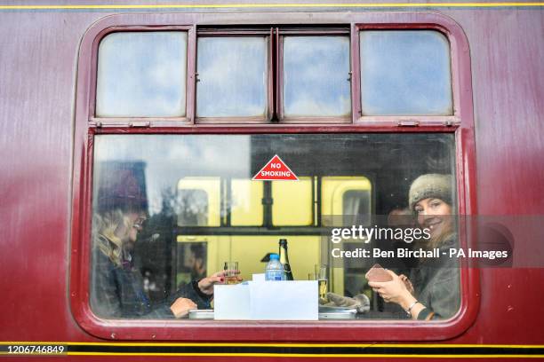 Racegoers peer out from vintage train carriages Toddington station, Gloucestershire, where they are catching a steam train service to Cheltenham...
