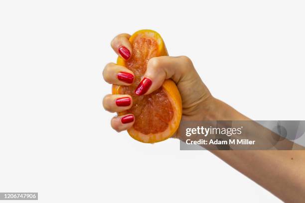 woman's hand squeezing a grapefruit - crushed photos et images de collection