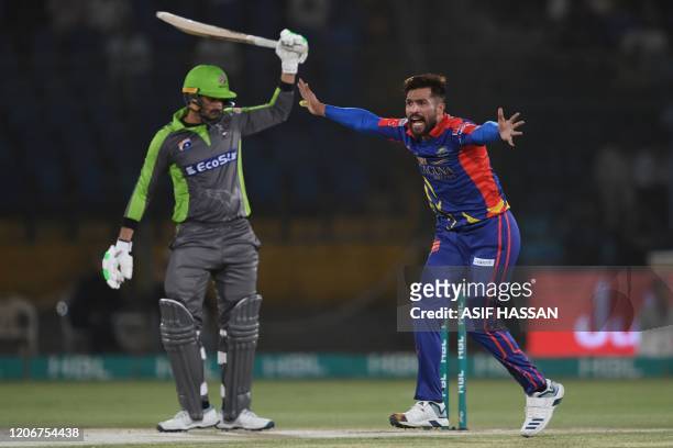 Karachi Kings's Mohammad Amir makes an appeal for caught behind the wickets against Lahore Qalandars's captain Sohail Akhtar during the T20 cricket...