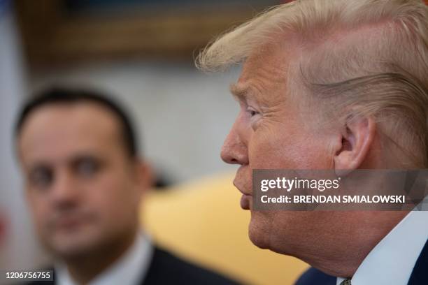 Ireland's Prime Minister Leo Varadkar listens while US President Donald Trump speaks to the press before a meeting in the Oval Office of the White...