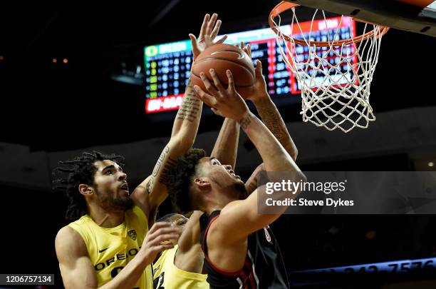 Addison Patterson of the Oregon Ducks blocks the shot of Timmy Allen of the Utah Utes during the second half at Matthew Knight Arena on February 16,...