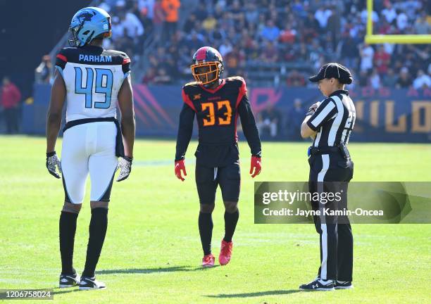 Line judge Maia Chaka stands on the field with tight end Donald Parham of the Dallas Renegades and running back Dujuan Harris of the Los Angeles...