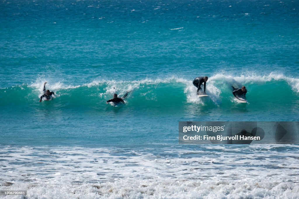 Four surfers catching a wave at the same time