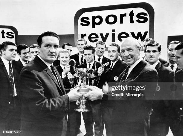 Manchester United football manager Matt Busby handing the Team of the Year Trophy to Celtic manager Jock Stein, while the rest of the Celtic team...