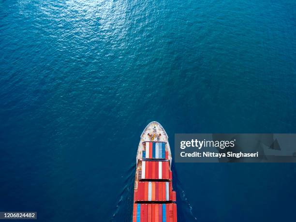 aerial view of cargo ships in containers sailing in the sea. - ship's bow stock pictures, royalty-free photos & images