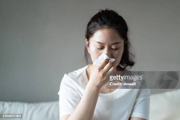 frustrated  woman using a tissue to sneeze - sonarse fotografías e imágenes de stock