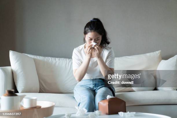 ill woman with the flu blowing her nose - blowing nose stock pictures, royalty-free photos & images