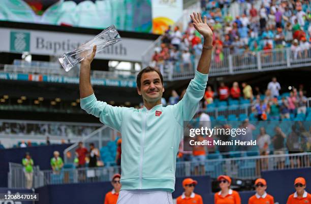 Roger Federer, of Switzerland, celebrates with the trophy after defeating John Isner, of the United States, 6-1, 6-4 during the final of the Miami...