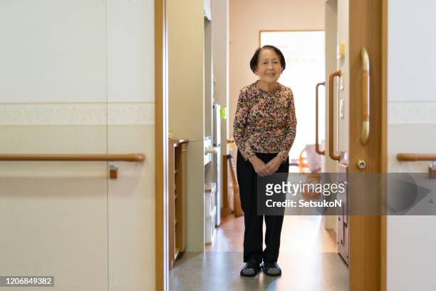 asian woman smiling in a nursing home - nursing home interior stock pictures, royalty-free photos & images