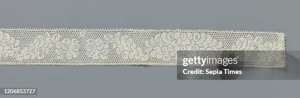 Strip of bobbin lace with circle between oval peony motif, Strip of natural-colored Dutch bobbin lace. The repetitive and symmetrical pattern...