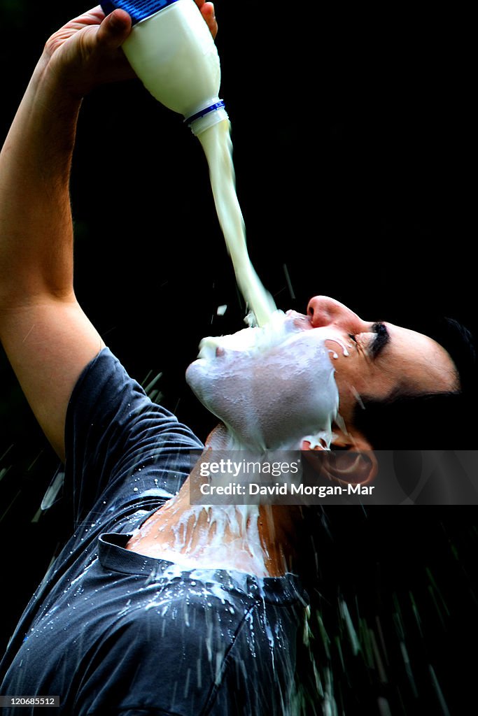 Man pouring milk on face