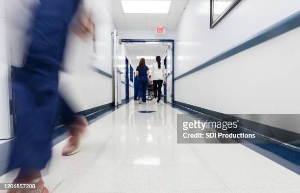 vue d’angle bas couloir occupé d’hôpital avec l’infirmière de fonctionnement méconnaissable - lino photos et images de collection