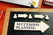Succession planning concept. Wooden figures and arrows.