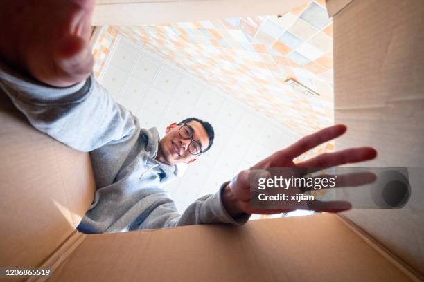 mann sucht in box finden sein überraschungsgeschenk - inner views stock-fotos und bilder