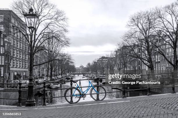 blue bicycle in the canals of amsterdam, the netherlands - isolated colour stock pictures, royalty-free photos & images