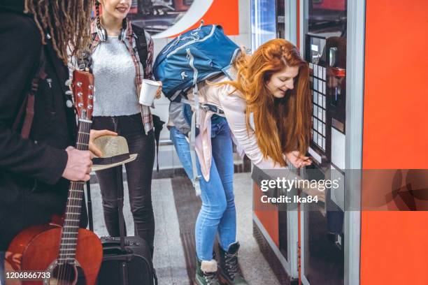 young travelers buy coffee at a vending machine - máquina de venda automática imagens e fotografias de stock