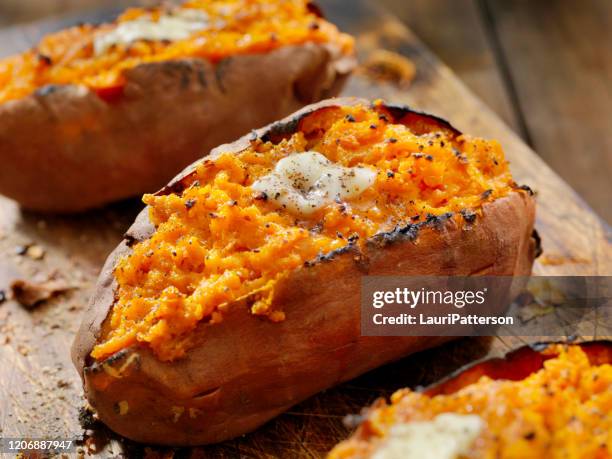 tweemaal gebakken, gevulde zoete aardappelen met smeltende boter en gebarsten peper - zoete aardappel stockfoto's en -beelden