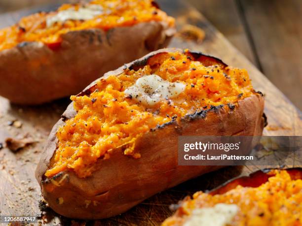 tweemaal gebakken, gevulde zoete aardappelen met smeltende boter en gebarsten peper - baked goods stockfoto's en -beelden