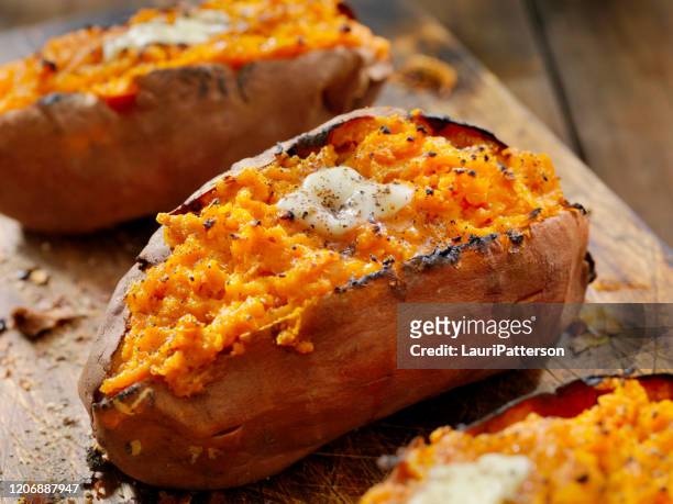 twice baked, stuffed sweet potatoes with melting butter and cracked pepper - stuffed stock pictures, royalty-free photos & images